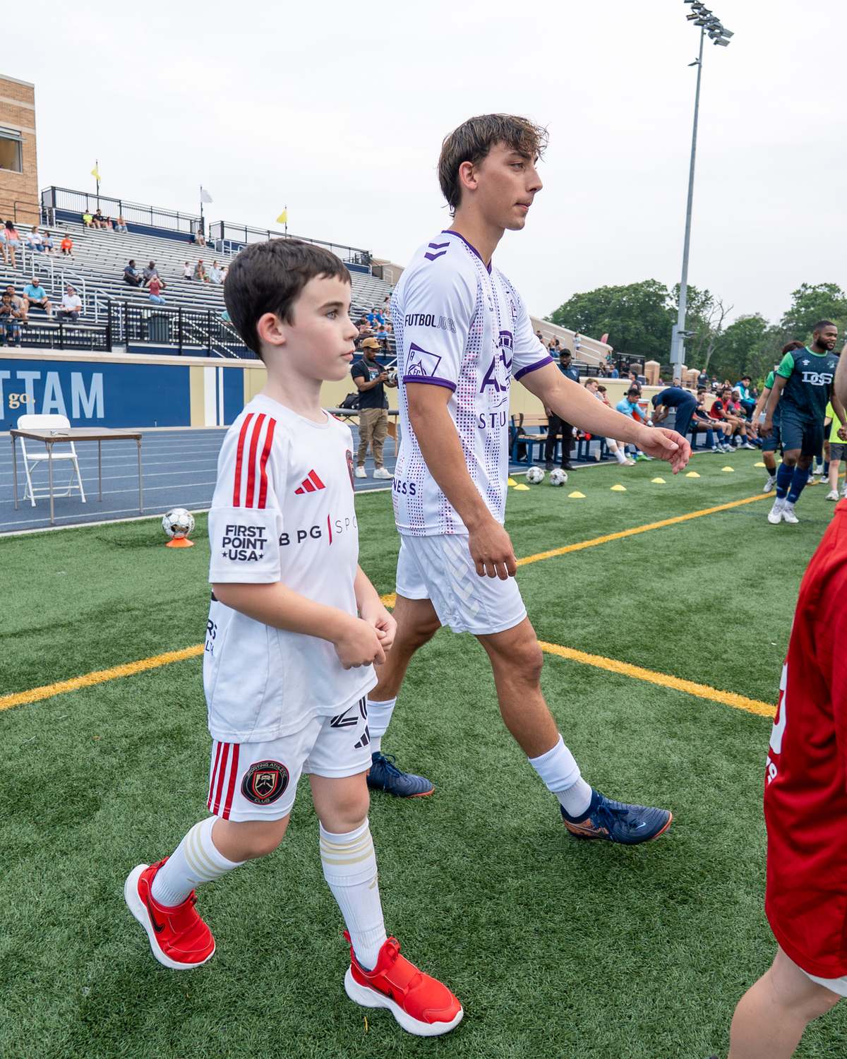 A player walking out alongside a young mascot