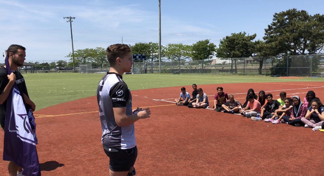 An ACFC player speaking to a group of students at a clinic